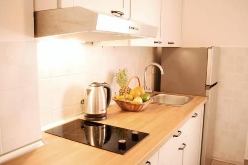 波梅纳Mljet Sunset Apartments的厨房配有水槽和柜台上的一碗水果