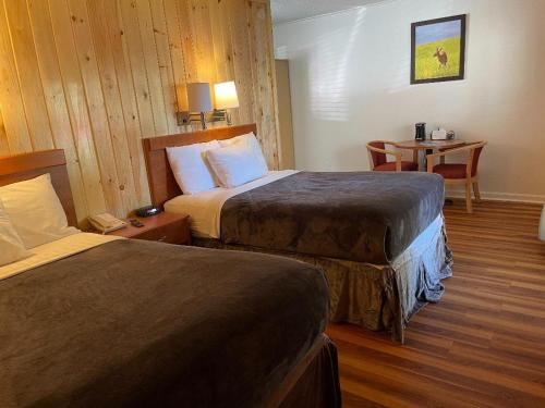 加特林堡Zoders Inn and Suites宾馆 的酒店客房设有两张床和一张桌子。