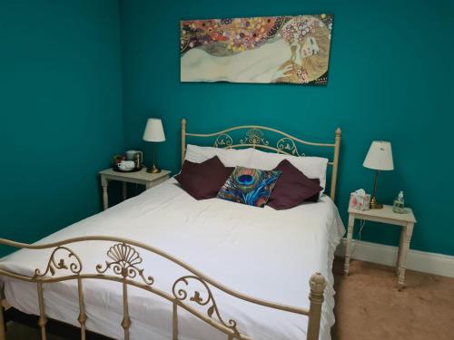 BallymahonSkellys的卧室配有白色床和蓝色的墙壁