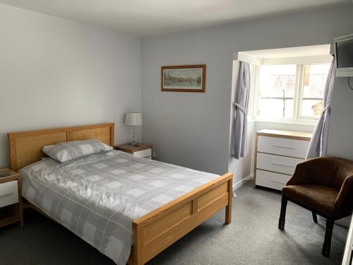里斯伯勒王子城The Red Lion Longwick, Princes Risborough HP27 9SG的卧室配有床、椅子和窗户。