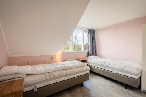 德瓦尔Nieuwlanderweg 55的带窗户的客房内的两张床