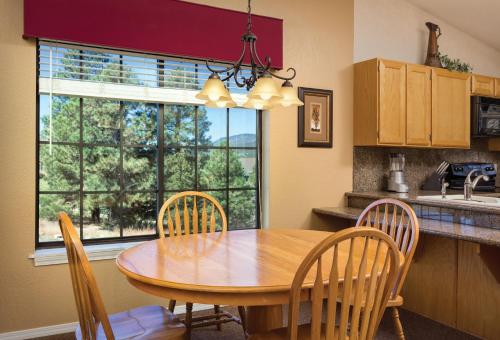弗拉格斯塔夫Club Wyndham Flagstaff的厨房配有木桌、椅子和窗户。