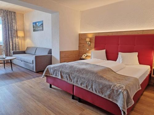 德弗雷根谷地圣雅各布嘎斯霍夫火绒草酒店的酒店客房设有一张大床和一张沙发。