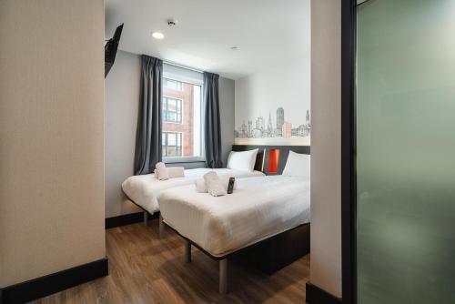 卡迪夫easyHotel Cardiff的酒店客房设有两张床和窗户。