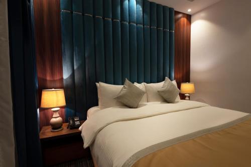 吉达Beach Time Villas Hotel的一间卧室配有一张带两盏灯的大型白色床。
