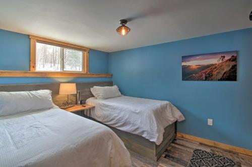 East BurkeCozy Condo Ski-In and Out with Burke Mountain Access!的一间卧室设有两张床和蓝色的墙壁