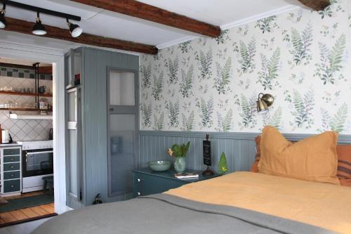 法尔肯贝里B&B Bland ormbunkar och rosor的一间卧室设有一张床和森林主题的墙壁