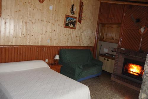 拉斯马哈达斯CASA RURAL JAVIER " ESTUDIO"e的一间卧室配有一张床、一把椅子和一个壁炉