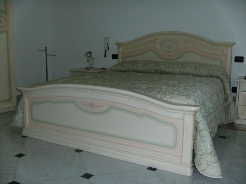 韦列Villa Gloria Bed & Breakfast的卧室内的一张大床,墙上有十字架