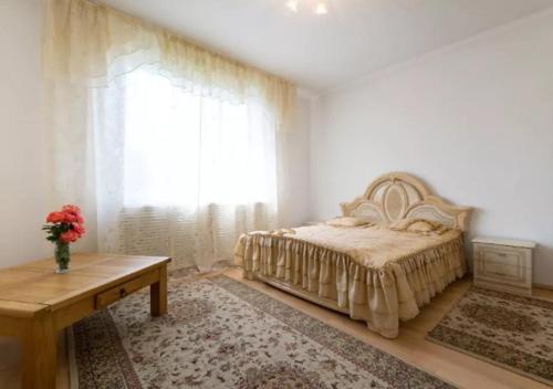阿拉木图Guest House On Maksimova 9的一间卧室配有一张床、一张桌子和一个窗户。