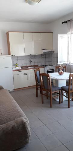 德雷斯Apartments Andrijana的一间带桌椅的厨房和一间用餐室