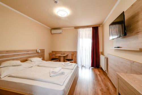 海吉什豪洛姆洛萨科萨达酒店的一间卧室设有两张床、一台电视和一张桌子