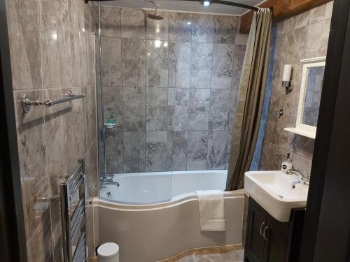 奇德尔Greenvale Barn的带淋浴、浴缸和盥洗盆的浴室