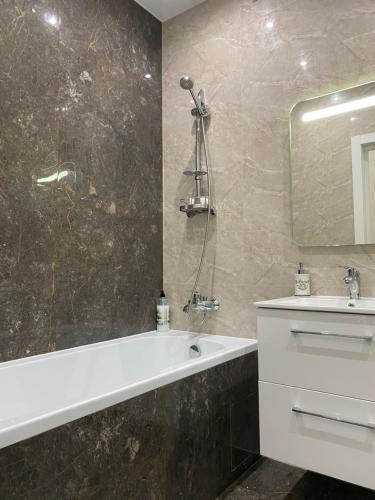 罗夫诺2 кімнатні ,Люкс апартаменти в ЖК Арена ,район автовокзалу的带浴缸、水槽和镜子的浴室