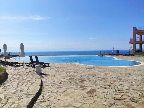 托波拉Nana apartment in Kaliakria resort的一个带椅子的游泳池,背景是大海