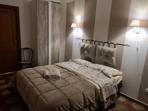 巴勒莫Agorà Sant’anna Apartment的卧室配有一张床,墙上有两盏灯