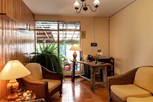 危地马拉Hostal Donde Regina的客厅配有椅子、桌子和窗户
