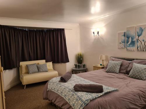 罗奇福德Westbury House的一间卧室配有一张大床和一把椅子