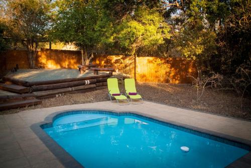 赫卢赫卢韦阿梅堪比旅舍的一个带两把椅子和一张桌子的游泳池以及一张野餐桌
