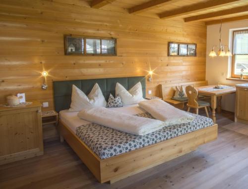 维拉巴萨Stifterhof的木制客房内的一间卧室,配有一张床