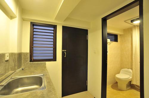 登巴萨恒河酒店公寓 的一间带水槽和卫生间的浴室以及窗户。