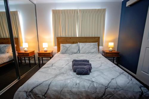 Hopetoun维乌克里斯特外莱基旅游假日公园的一间卧室配有一张大床,两台桌子上放着两盏灯