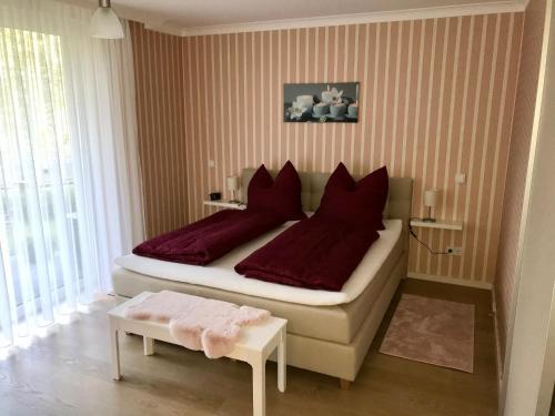 拜罗伊特Ferienhaus am Park am Röhrensee的一间卧室配有一张带红色枕头的大床