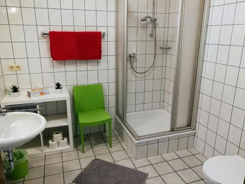 KülsheimWinzerhof Spengler的带淋浴和绿色椅子的浴室