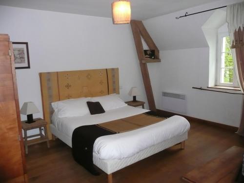Leubringhen迪日卡农场旅馆的一间卧室配有一张大床和木制床头板