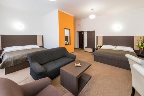 斯皮什新村Penzión RESA的酒店客房带两张床、一张沙发和一个客厅。