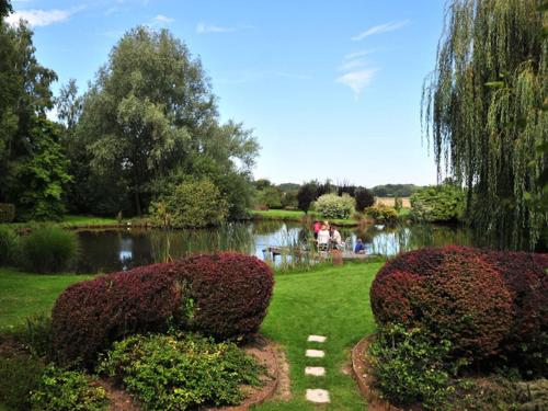 TroussuresLes Roulottes de Troussures的一个带池塘和灌木的花园