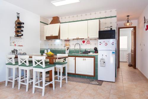 塞博河畔卡莱塔Casita Corazón的厨房配有白色橱柜和白色冰箱。