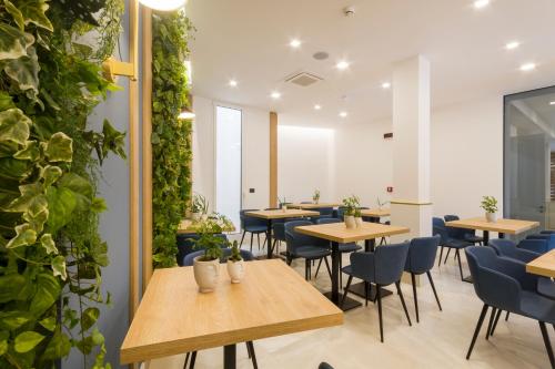 奥特朗托Hotel Bellavista - Boutique Hotel的一间设有桌椅的餐厅,种植了植物