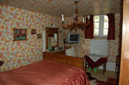 Hatrival莱斯吉奈住宿加早餐旅馆的卧室配有一张床,墙上配有电视。