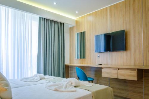 萨索斯Anassa Blue Thassos的酒店客房,配有床和电视