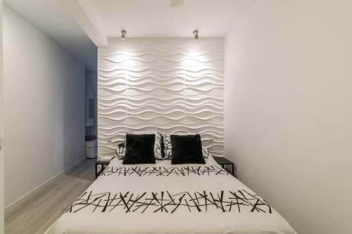 多列毛利诺斯Roca Chica A. Apartamento 211的一间卧室配有一张带黑色枕头的大床
