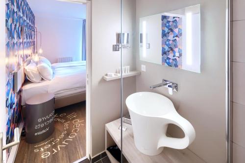 费内-伏尔泰The Residence Hotel Geneva Airport的一间带水槽和镜子的小浴室