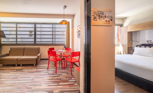 特拉维夫本叶湖达公寓式酒店的酒店客房带一张床、一张桌子和椅子