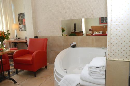 伦韦格地区诺伊豪斯斯福霍夫精品酒店的一间带红色椅子和浴缸的浴室