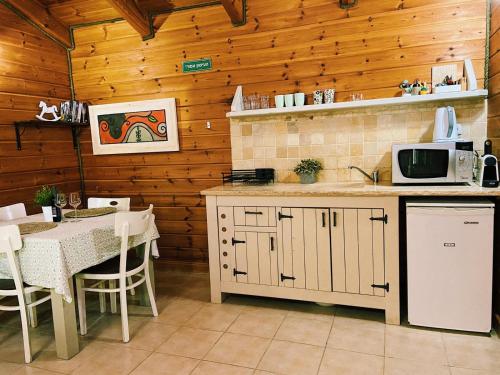 Neot GolanJulie's Cabins的厨房配有桌子和带微波炉的台面