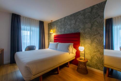 里瓦德奥HOTEL JAVIER MONTERO的酒店客房,配有一张红色床头板的床