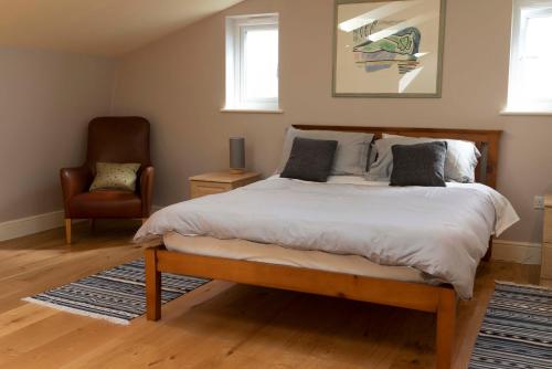 剑桥Garden Villa的一间卧室配有一张大床和一把椅子
