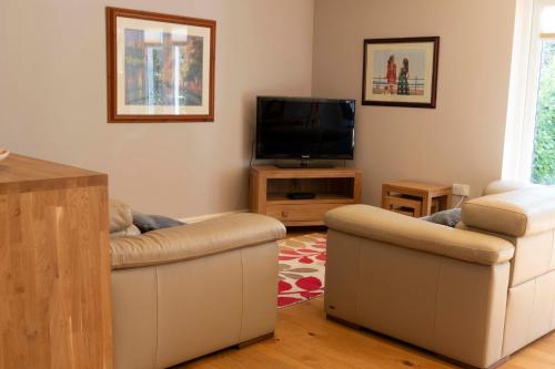 剑桥Garden Villa的客厅配有2张沙发和1台平面电视