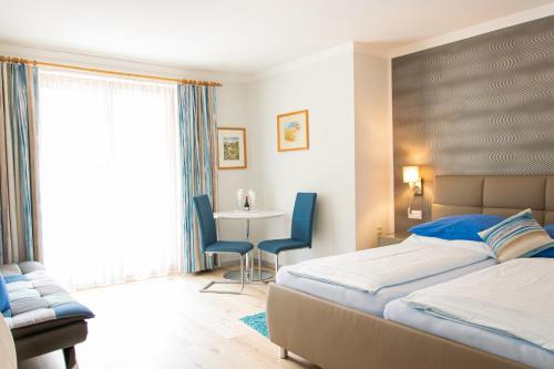 滨湖费尔德Hotel Burgstallerhof的卧室配有一张床和一张桌子及椅子