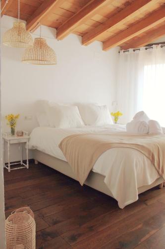 MontagutEl Niu Casa Rural的一间卧室配有一张铺有木地板的白色床单。