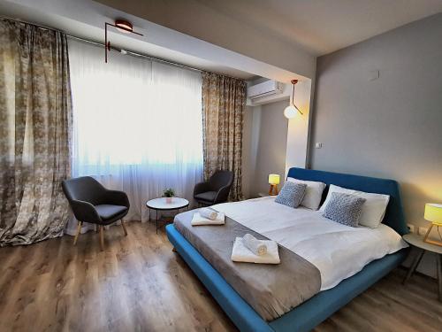 斯科普里Guest rooms Denicija的一间卧室配有一张大床、两把椅子和一扇窗户