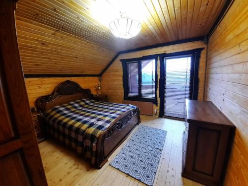 亚列姆切Карпатский Рай的小木屋内一间卧室,配有一张床