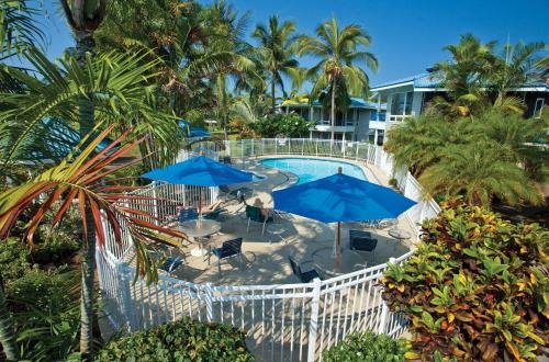 科纳温德姆毛纳罗亚乡村酒店的享有带蓝伞的游泳池的顶部景致