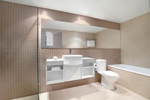 达尔文潘达纳斯曼特拉酒店的浴室配有卫生间、盥洗盆和浴缸。