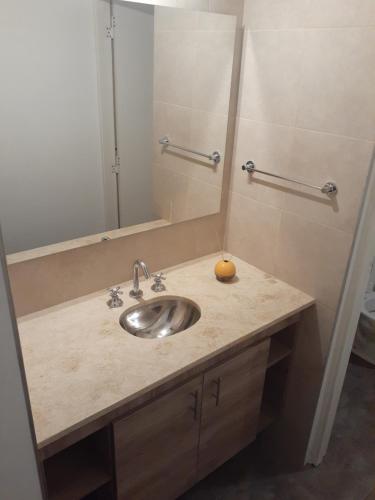 卢汉德库约Casa Elisa的浴室水槽,上面有镜子和橙子